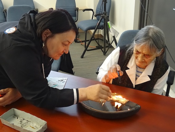 In Cambridge Bay, Cathy Towtongie, the president of Nunavut Tunngavik Inc., and 85-year-old elder Mary Kaniak, light the qulliq at the start of the Inuit Circumpolar Council-Canada annual general meeting on Sept. 15. (PHOTO BY JANE GEORGE)
