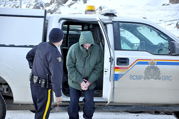 The convicted pedophile and former Catholic priest, Eric Dejaeger, shields his face after arriving under police supervision at the Nunavut Court of Justice in Iqaluit Nov. 10. Dejaeger is appealing at least some of his 32 convictions for sex crimes against Igloolik children committed between 1978 and 1982. (PHOTO BY THOMAS ROHNER)