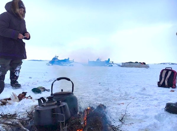 Lucassie Cookie waits for the kettle to boil for tea about 50 kms outside of Umiujaq. Inuit communities north of the Arctic Circle are still waiting for the sun to return and the days to grow longer but Nunavik communities further south enjoy a few more hours of light this time of year. Cookie and Eddie Qumaluk were out hunting in the open water of Hudson Bay Jan. 9 when they decided to take a break for tea. (PHOTO BY EDDIE QUMALUK)