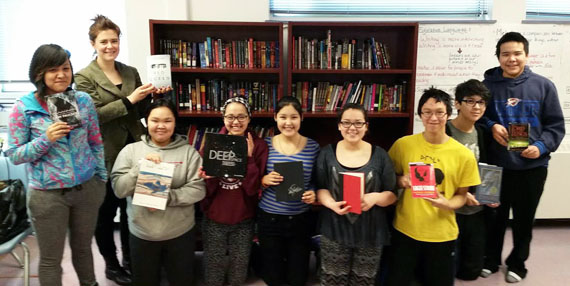 Jonah Amitnaaq high school  grade 9 students hold up the books they're currently reading; from left, Brianna Niego, teacher Bethany Guther, Crystal Haqpi, Sipporah Nukik, Hattie Amitnak, Carla Rose Kaayak, Dylan Nanooklook, Nanurluk Noah and Joseph Owingayak. Thanks to a new tech grant through Best Buy Canada, the Baker Lake high school will purchase 60 e-readers, which will give students better access to reading material. (PHOTO COURTESY OF G. KENNEDY)
