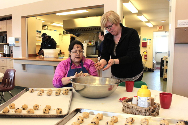Carla Qualtrough, former paralympian and now federal minister of sport and persons with disabilities, rolls banana macaroon cookies March 11 with Iqaluit's Amanda Arnarjuaq who works for the Inclusion Café, an Iqaluit cafe and catering services that employs people who have physical and intellectual disabilities. Qualtrough was in town to catch some Arctic Winter Games hockey action and to get to know the services offered through the Nunavut Disabilities Makinnasuaqtiit Society such as the café. Qualtrough, who said she is legally blind, also took the opportunity to sign a bilateral agreement with the Government of Nunavut to expand sporting programs. Ottawa promised to contribute up to $1 million over four years, with matching GN grants. The minister also gave Nunavut an extra $100,000 to help defray the cost of athletes' travel to Nuuk for the 2016 AWG. (PHOTO BY LISA GREGOIRE)