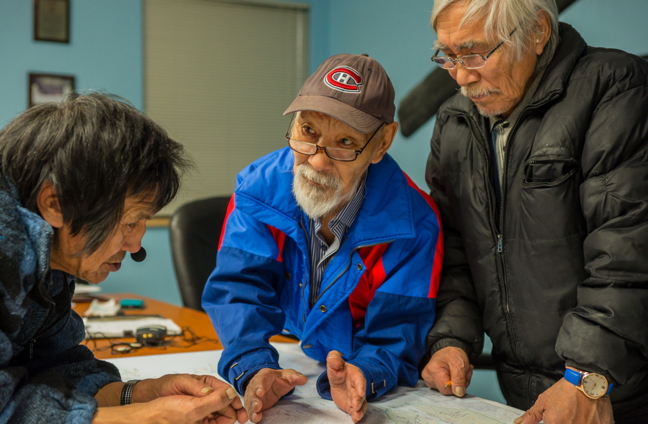 Honore Aglukka, middle, speaks with interpreter Hugh Haqpi, left, and Pie Sanertaut during a discussion of Wager Bay's marine ecosystem in Naujaat in January. (PHOTO BY JOVAN SIMIC/PARKS CANADA