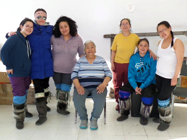 Kimmirut women model kamiks they recently made with the help of two elder instructors including Annie Ikkidluak, seated in middle. The five-month program just wrapped up March 31 and allowed enough time for working and non-working women to complete their kamiks during day and evening instruction time. Monica Gardner, Kimmirut's community justice outreach worker, organized the program with funding through Nunavut's Department of Culture and Heritage and with materials supplied by the Ilisaqsivik Society in Clyde River. From left: Ningeorapik Kolola, Padluk Judea, Lysee Itulu, Ikkidluak, Jeannie Padluq, Levena Uyte and Kayla Nutarasungik. Read more about the program later on Nunatsiaqonline.ca. (PHOTO BY MONICA GARDNER)