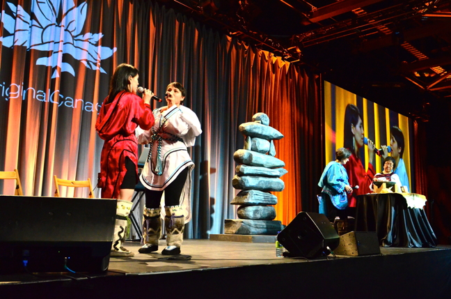 Beatrice Deer, in red, and Evie Mark throat sing April 26 for an audience in Montreal gathered for the annual Rendez-vous Canada travel trade show, the biggest such tourism trade event in the country. The regions of Nunavik and James Bay Eeyou Istchee were featured during a special luncheon sponsored by the Aboriginal Tourism Association of Canada. The Nunavik Tourism Association's presentation included emcee and presenter Lisa Koperqualuk, Kangiqsujuaq elder Maggie Kiatainaq, who tended the qulliq, and entertainment from the throatsingers. Beatrice Deer also performed with a guitarist during the luncheon which attracted a rapt audience of about 1,700. (PHOTO BY ISABELLE DUBOIS)