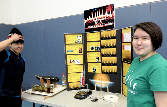 Salluit students Elaijah Isaac and Jenny Okituk stand by their project Qullik 2.0 during the Nunavik Regional Science Fair in April. The project, which just won a bronze medal at a national science fair, which looks at which types of fuel burn longest in the traditional Inuit lamp. (PHOTO COURTESY OF KSB) 