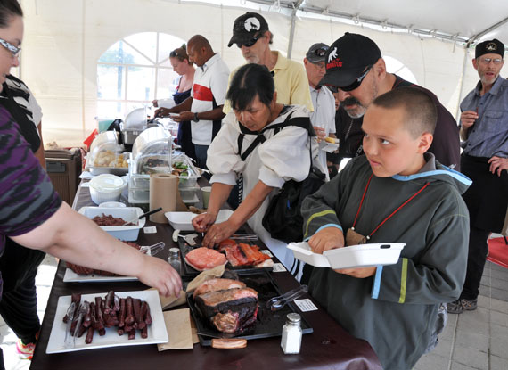 Eleven-year-old Albie Galliford tucks into some seal meat following the unveiling of Ahqahizu at York University. (PHOTO BY SARAH ROGERS)