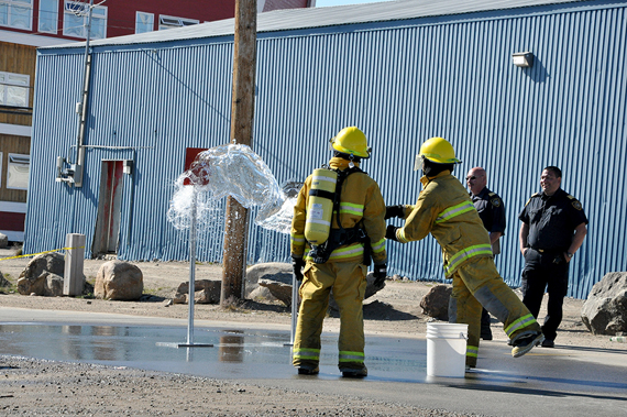Where there's smoke: Nunavut firefighters compete in drills Aug. 4 in a parking lot beside the Iqaluit post office. The firefighters, which hail from 13 communities across Nunavut, are getting ready for the Aboriginal Firefighters Association of Canada's national firefighting competition. That contest will be hosted Aug. 13 by the Six Nations of the Grand River, located outside of Hamilton, Ontario. (PHOTO BY THOMAS ROHNER)