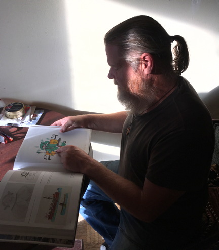 William Watt, Annie Pootoogook's former partner, looks at a book of Inuit artworks that contain drawings by Pootoogook's relatives at his south Ottawa apartment Oct. 3. (PHOTO BY COURTNEY EDGAR)