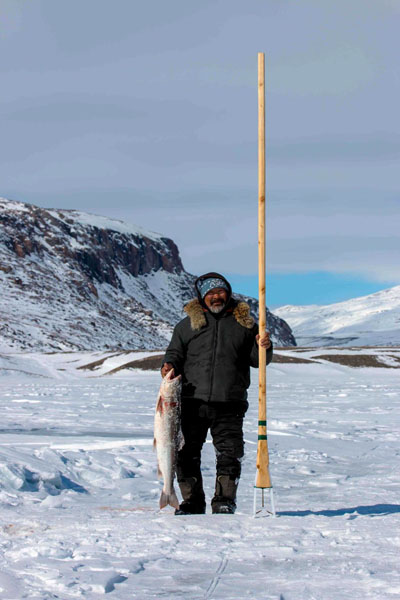The former MLA, David Iqaqrialu, displays a fish he caught using his kakivak. (FACEBOOK IMAGE)