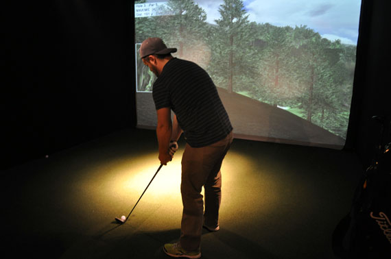 Fore! This year-round Kuujjuaq golfer lines up a shot Nov. 26 from the Nunavik community's new simulated course. Local businessman Dennis Lock opened NunaGolf earlier this year, complete with two golf simulators, a bar and a covered terrace in the works. Read more about the new social club this week at Nunatsiaqonline.ca. (PHOTO BY SARAH ROGERS) 