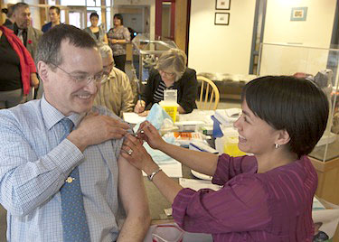 Nunavut's finance minister (then health minister) Keith Peterson, gets a flu shot from public health nurse Susie Pearce at a 2012 clinic in Iqaluit. (FILE PHOTO) 