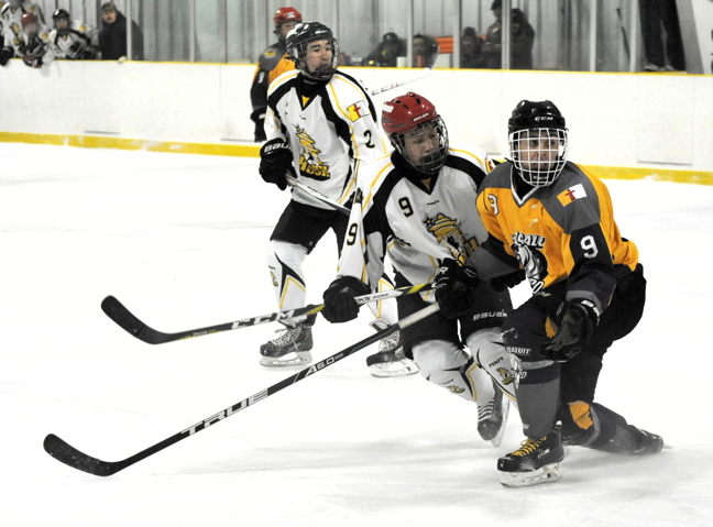 Rankin Inlet players in white battle with Iqaluit in yellow during a Nunavut midget territorial hockey tournament in Arviat March 4. Teams and players vying for a spot on the Arctic Winter Games roster came out this past weekend to play some serious hockey including those from Rankin Inlet, Whale Cover, Baker Lake, Coral Harbour, Gjoa Haven, Igloolik and Iqaluit. (PHOTO BY ERIC ANOEE)