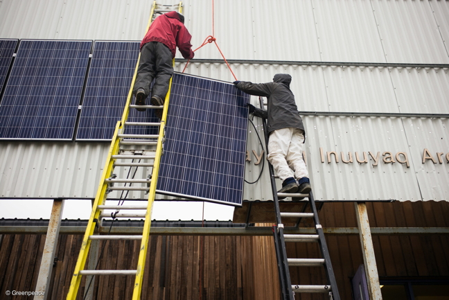 Vancouver Renewable Energy Co-op solar installer Duncan Martin, left, and Greenpeace Logistics Coordinator Claude Beauséjour install solar panels on the Clyde River community hall in the summer of 2016. (FILE PHOTO)