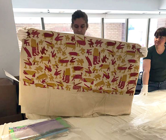 A staff member from Dorset Fine Arts in Toronto holds up a 50-year-old piece of fabric printed in Cape Dorset. DFA recently uncovered 175 fabric pieces, all printed in the 1960s and 1970s by Inuit artists at Kinngait Studios, and donated them to the Textile Museum of Canada in Toronto. The two organizations are working to create an exhibit of the pieces, which will be the largest of its kind in the county. Read more later at NunatsiaqOnline.ca. (PHOTO COURTESY OF DFA) 