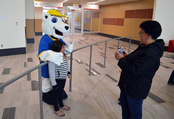 Canadian North's friendly polar bear mascot makes the rounds posing with passengers at the new Iqaluit International Airport terminal, which officially opened Aug. 9. Sheila Oolayou snaps a photo of of her daughter here before catching a flight to Montreal. While the terminal will handle all plane traffic going forward, the grand opening ceremony for the facility isn't scheduled until September. (PHOTO BY STEVE DUCHARME)