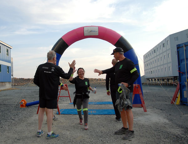 Raglan Mine employee Lizzie Kulula of Quaqtaq is greeted at the end of a five kilometre run she took part in last month at the Nunavik mine site. The Glencore nickel mine is marking its 20th anniversary of operations this year and to celebrate, the mine shut down one of its production roads for two hours to allow more than 100 staff members take part in the run. (PHOTO BY M. LAUZON/RAGLAN)