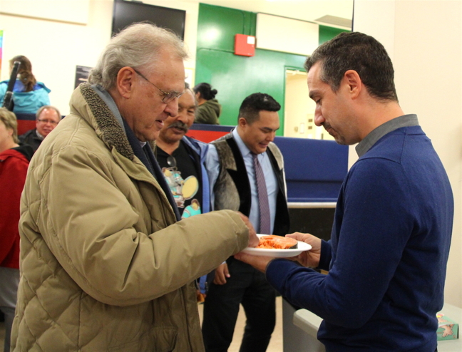 World-renowned Canadian health advocate Stephen Lewis, left, tries country food for the first time with Ottawa Hospital tuberculosis researcher Dr. Gonzalo Alvarez during a community feast hosted by Nunavut Tunngavik Inc. in Iqaluit Sept. 6. One-time deputy executive director of UNICEF and Canada's Ambassador to the United Nations, Lewis is co-founder and co-director of the advocacy organization AIDS-Free World which works to decrease AIDS and TB. Lewis is now in Igloolik where he will be gathering information about TB among northern Indigenous peoples. Lewis met with elders while in Iqaluit who told him of loved ones with TB whisked away to southern hospitals in the 1950s and 1960s. 