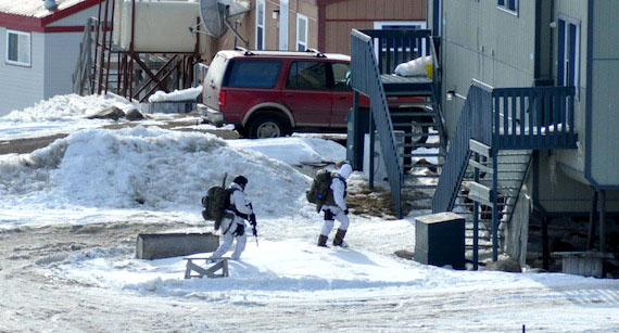 Armed police in white winter camouflage search around houses in Iqaluit's Happy Valley neighbourhood which was locked down for 41 hours between April 28 and April 30, 2015. (PHOTO BY THOMAS ROHNER) 