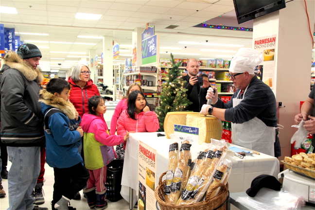 Introducing the big cheese: Northmart deli manager Mike Thorton cracks into a 70-lb round of Parmigiano Reggiano during a cheese-cracking event Nov. 17 at the Iqaluit grocery store. Some came just to taste the exotic treat while others lined up to purchase a slice to take home. The cheese, priced at $6.59 per 100 g, was a good deal, Thorton said, and it sold quickly.