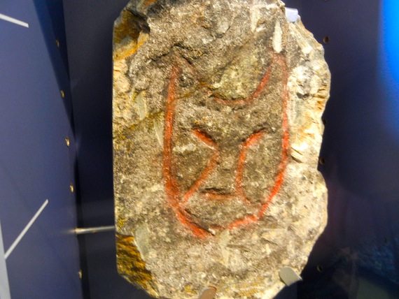 A cat-like face peers from a rock on display at the Pingualuit provincial park's visitors centre in Kangiqsujuaq in 2010. The engraving, collected in the 1960s, hails the nearby island of Qajartalik. (PHOTO BY JANE GEORGE)
