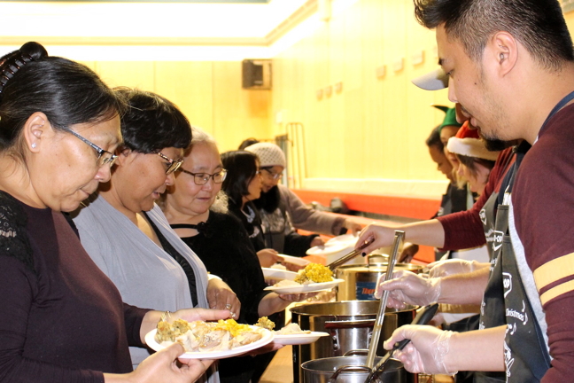 RCMP and Calm Air staff serve up turkey dinners to Naujaat District Education Authority members during education week. (PHOTO BY BONNIE RUSSELL)
