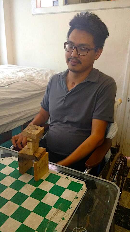 Napu Boychuk eyes the tower he was recently able to build, by himself, with wooden blocks, a huge achievement because, until recently, he had no use of his arms. (PHOTO COURTESY OF T. BOYCHUK)