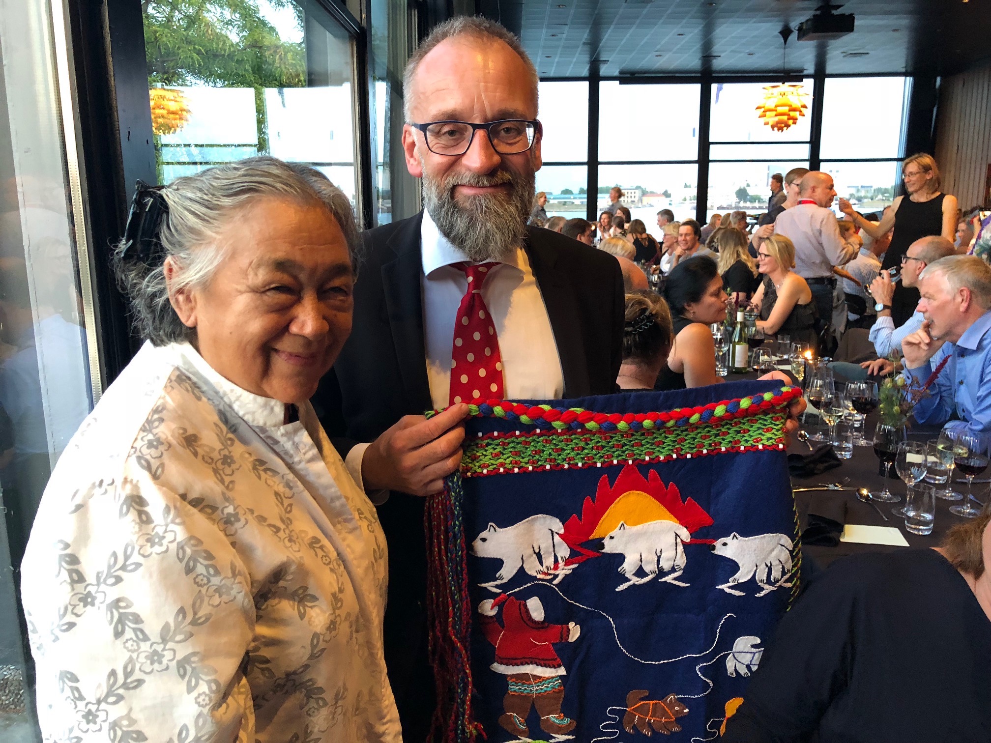 Levinia Brown of Rankin Inlet presents a wall hanging she made to Dr. Anders Koch, the organizer of the International Congress on Circumpolar Health in Copenhagen on Aug. 15. Brown, who is a former Nunavut health minister, was a keynote speaker at the conference where she spoke about changes in Inuit Nunangat from 1940 to today. “There were no doctors and nurses and Inuit looked after each other,” Brown said of those early years, noting that now Nunavut has its own nursing program. (PHOTO BY JANE GEORGE)