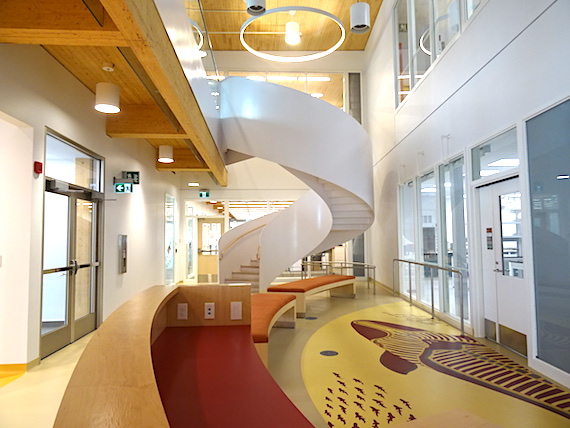 A spiral staircase beckons upward at the end of this unoccupied hall on the first floor of the main science building. The artwork on the floor,  