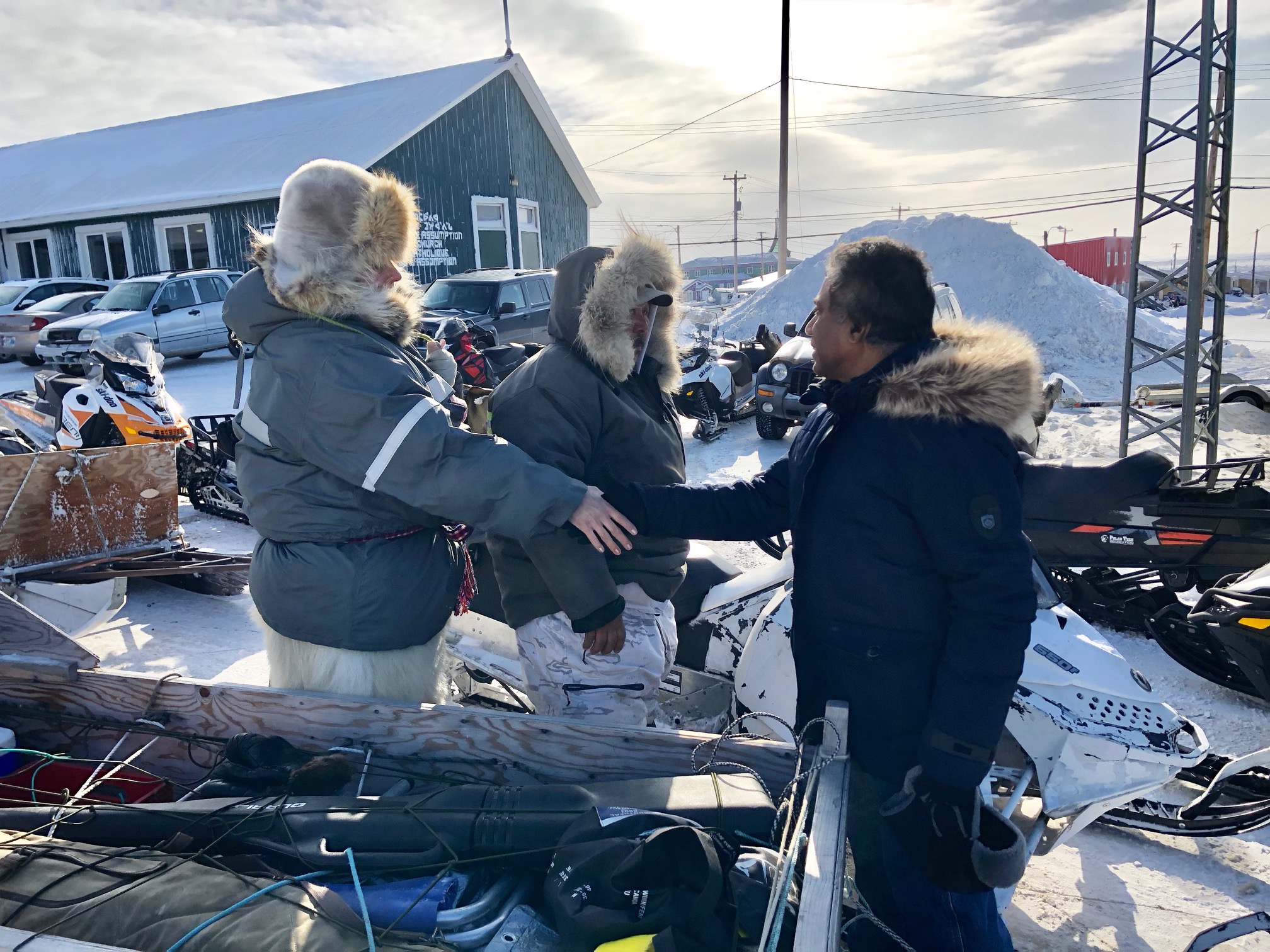On Sunday morning Amal Roy, the father of missing Iqaluit teenager, Ambar, greets searchers ready to leave with their snowmobiles from the Nunavut capital. But later, on Sunday evening, police and Roy’s parents said that the searchers had not found any signs of the boy, 18, last seen March 13. “Our heartfelt thanks and gratitude to friends on skidoos and RCMP who continued their search in Road to Nowhere areas for the second day,” Bijoya Roy said in a public message. “As they did not find any bad signs we are still very hopeful that my son is somewhere and safe. Our heartfelt appreciation and thanks to all Iqaluit residents for their continued support and prayers for my son. We hope to get him back soon.”  The search effort continues on Monday, with volunteers on snowmobiles asked to come to the Nunavut Wildlife Management office at 10 a.m. Read more later about the search for Amal Roy on Nunatsiaq.com. (Photo by Jane George)