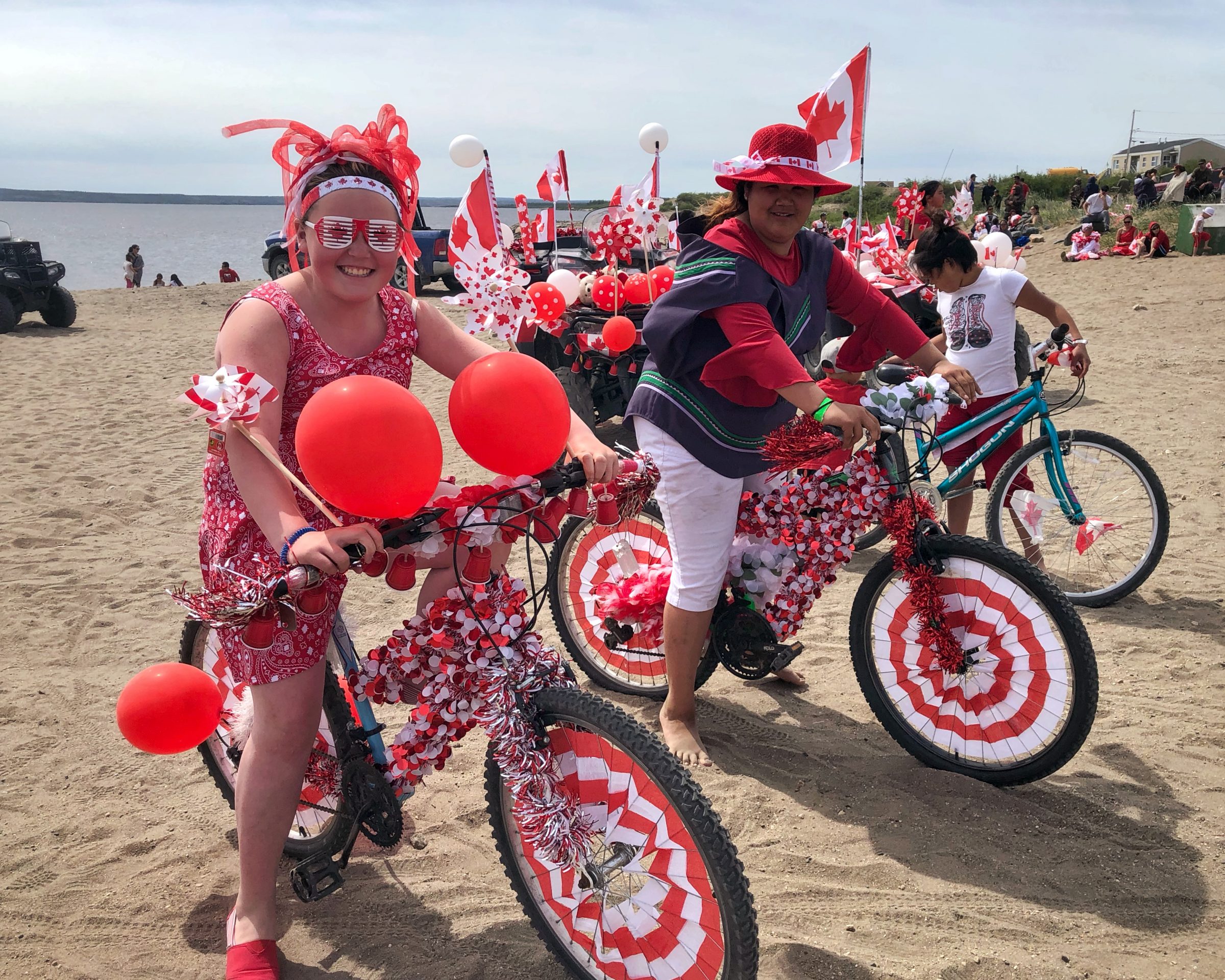 Aiva Lingard and Jessica Berthe celebrate Canada Day in Kuujjuaq by riding around on their Canada-inspired bicycles. (Photo by Isabelle Dubois)
