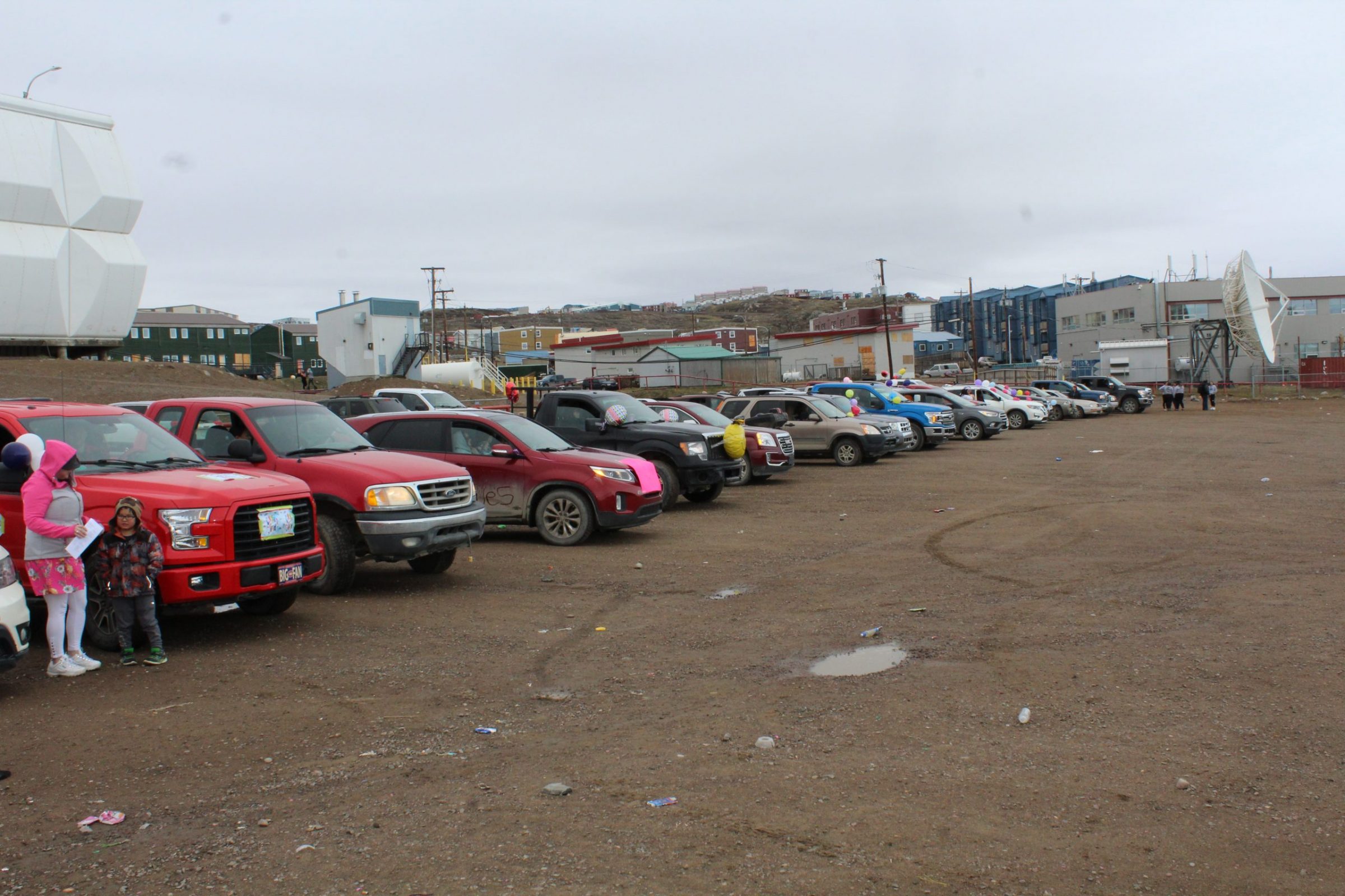 Iqaluit’s graduating class lined up in vehicles in front of Nakasuk School on Tuesday, June 23. They sang along to Song of the Land, and then proceeded to parade through the city. Onlookers waved and honked their horns. Vehicles were decorated with balloons, signs and paint. Some grads wore dresses, suits and graduation caps. (Photo by Meagan Deuling)