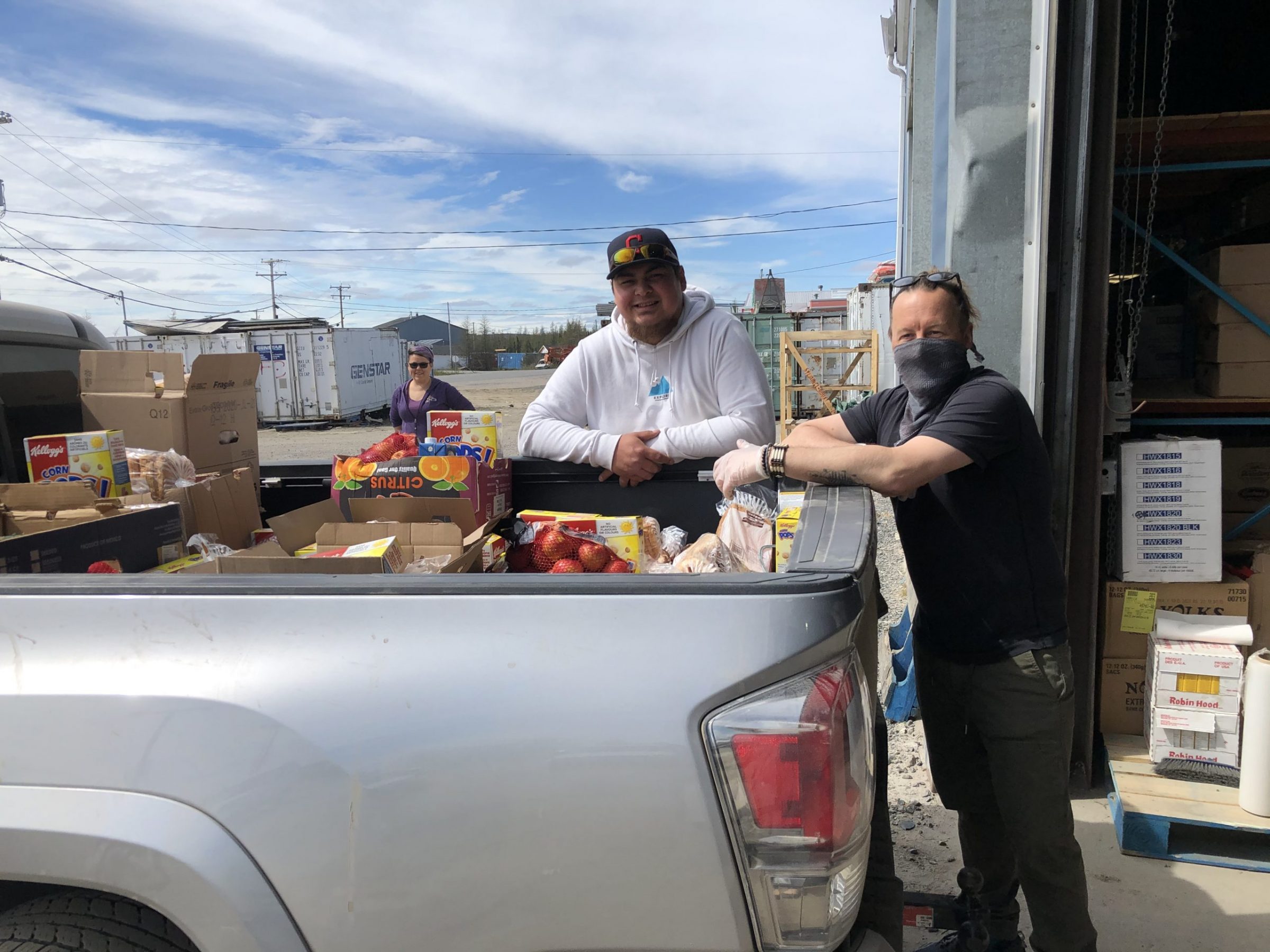 Volunteers and staff with the Ungava Wellness Program in Kuujjuaq help deliver food to low-income families with children on June 26. Here staffer Attasie Saunders is seen in the background, with staffer Laz Iserhoff in the centre and volunteer Daniel Cooper to the left. (Photo courtesy of  Anita Gordon)