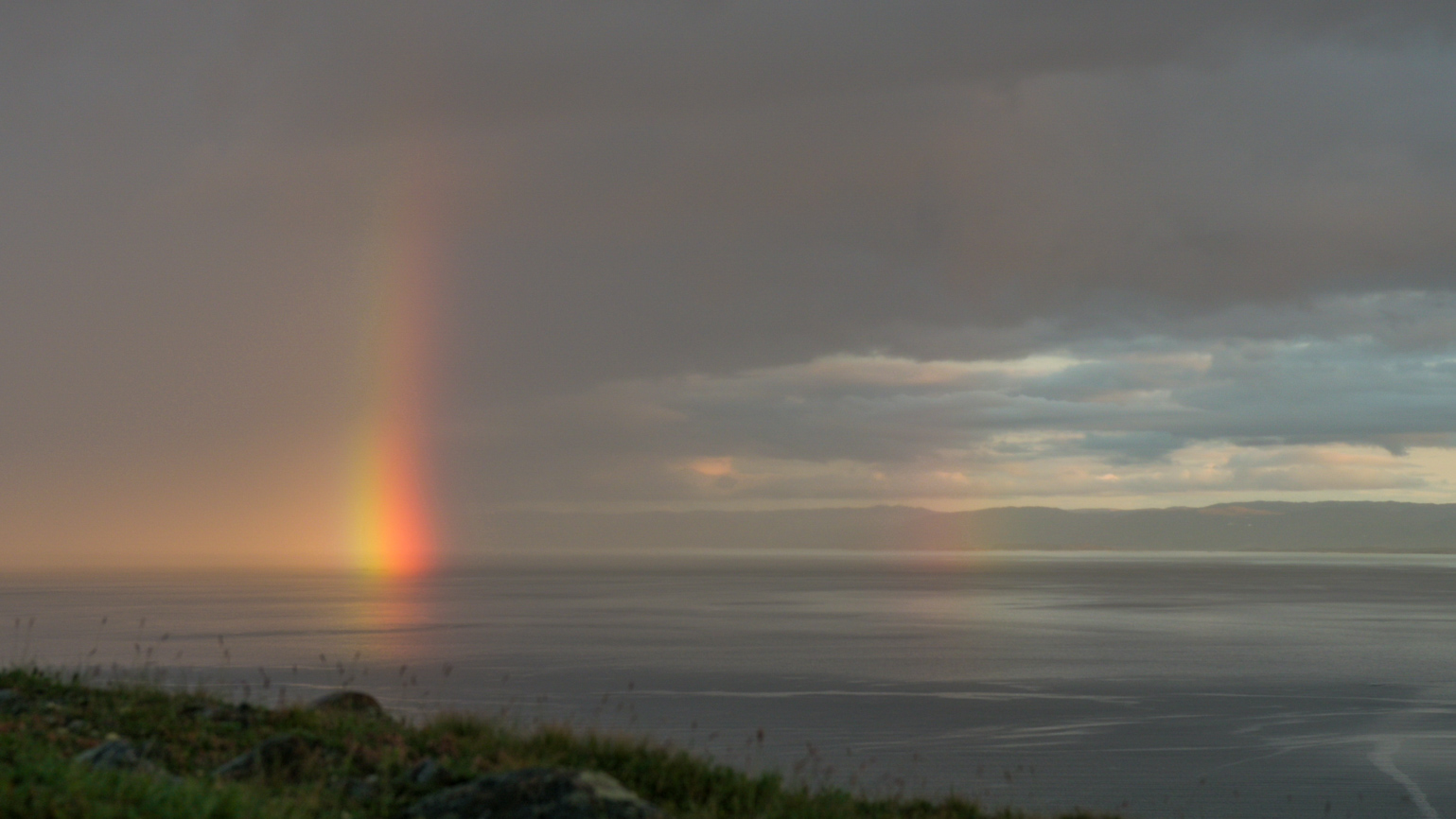 After a sudden downpour swept through Iqaluit and out into Frobisher Bay on Saturday, Aug 1, the setting sun emerged and caught the fleeting remnants of the rainstorm, creating this rainbow. (Photo by Dustin Patar)