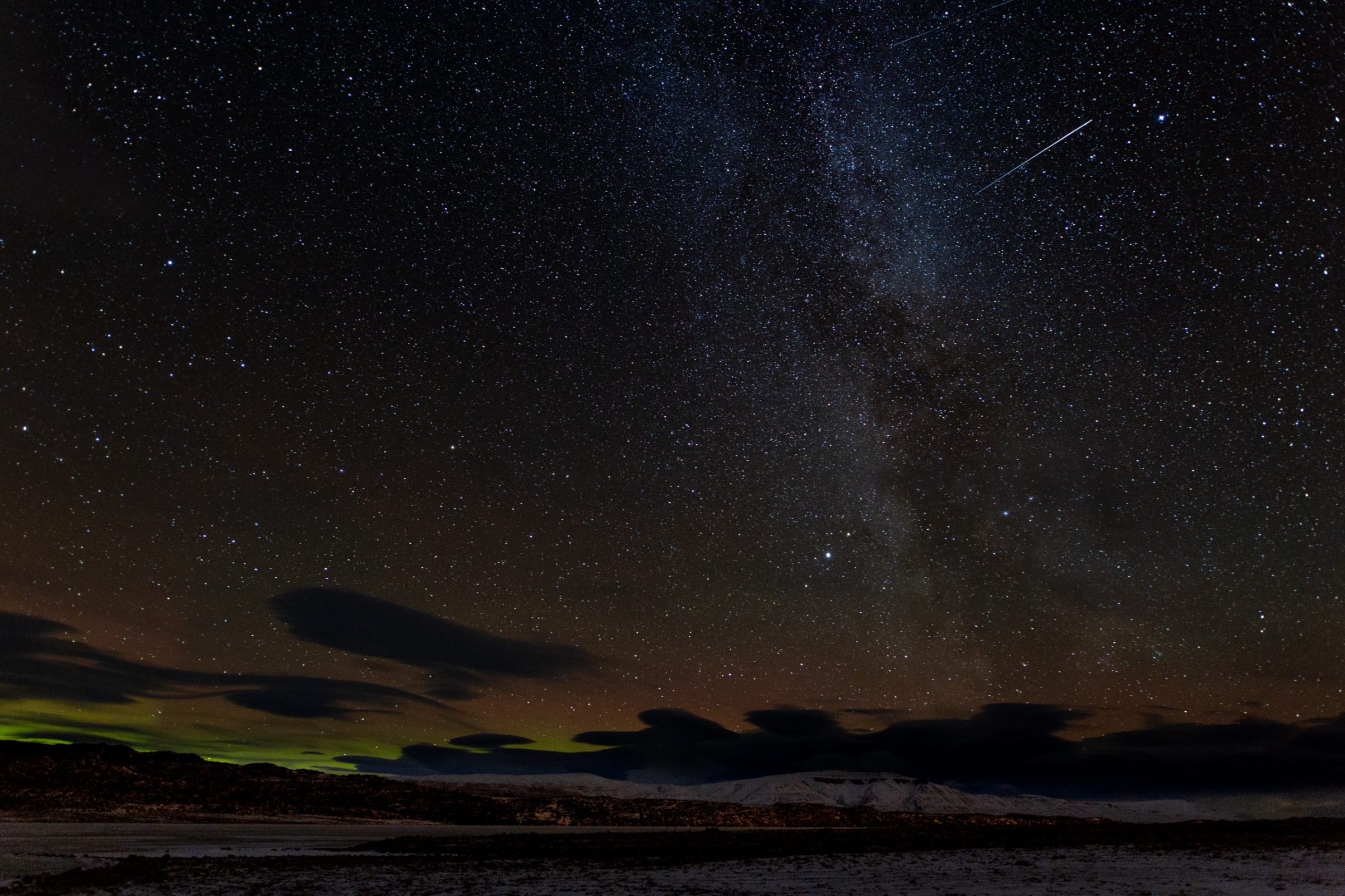 A meteor streaks across the backdrop of the Milky Way