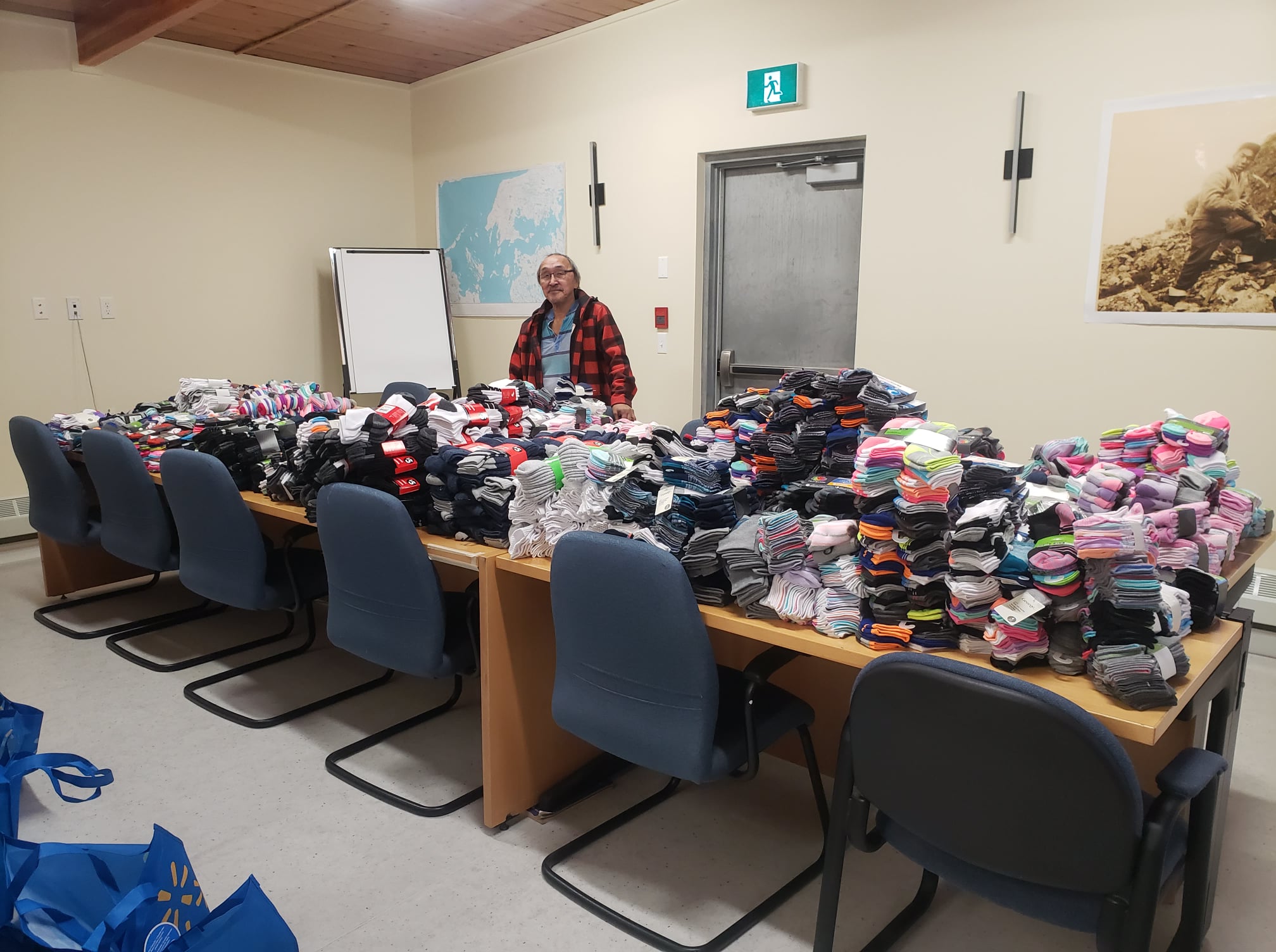 Ikey Evalik, TMAC Resources Inc.’s Inuit impact benefit agreement coordinator, helps prepare 1,500 pairs of socks to be distributed to Kitikmeot students through the region’s elementary schools ahead of Christmas. He’s seen here on Dec. 1 at TMAC’s office in Cambridge Bay. The company says that, with its Nunavut operations slowed by the COVID-19 pandemic, the socks were purchased with funds usually dedicated to site Christmas activities. (Photo courtesy of TMAC)