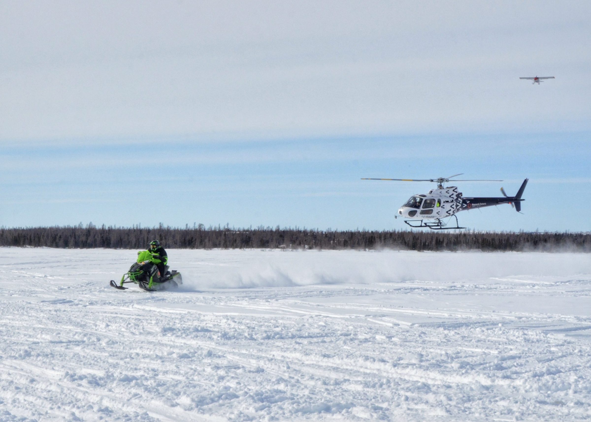 George Kauki is the winner of the men’s division of Kuujjuaq’s annual Easter Cross-Country Snowmobile Race held on Monday. He’s seen here approaching the finish line at Tasialuk (Stewart Lake), after racing to Tasiujaq and back, covering just over 250 km. He’s followed by a Nunavik Rotors helicopter, which patrolled the trail for safety during the race, with a nurse onboard in case of emergencies. (Photo by Isabelle Dubois)