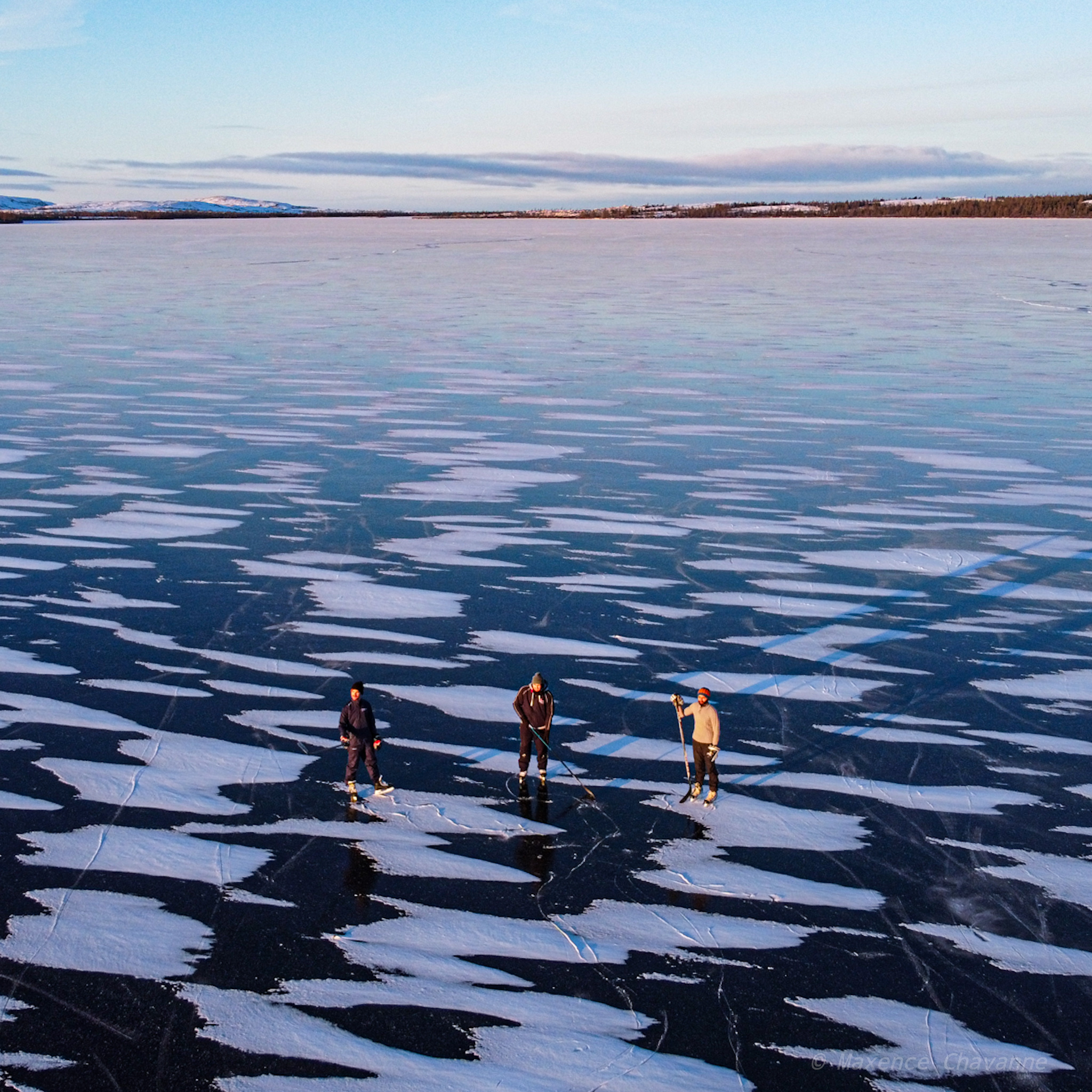 Three hockey players take to the ice on a recently frozen Stewart Lake near Kuujjuaq on Nov. 11. (Photo by Maxence Chavanne)