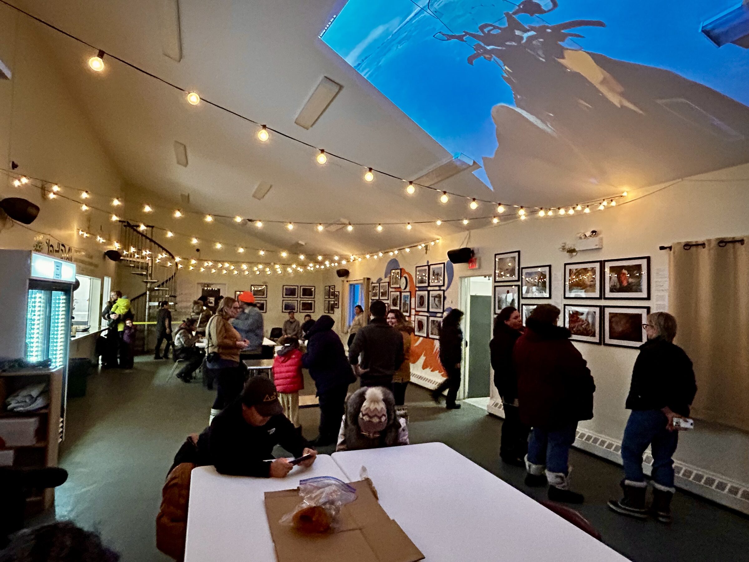 Dozens of people visit the Qajuqturvik Community Food Centre in Iqaluit Feb. 14 for the launch of a photo and video exhibition about food sovereignty. The exhibit includes photos of country food captured by hunters and youth in Kinngait and Pond Inlet as part of a three-year research project on food sovereignty in Nunavut. Dozens of people visited the exhibit throughout the evening with country food provided to them. The food centre will host the installation until September. (Photo by Arty Sarkisian)