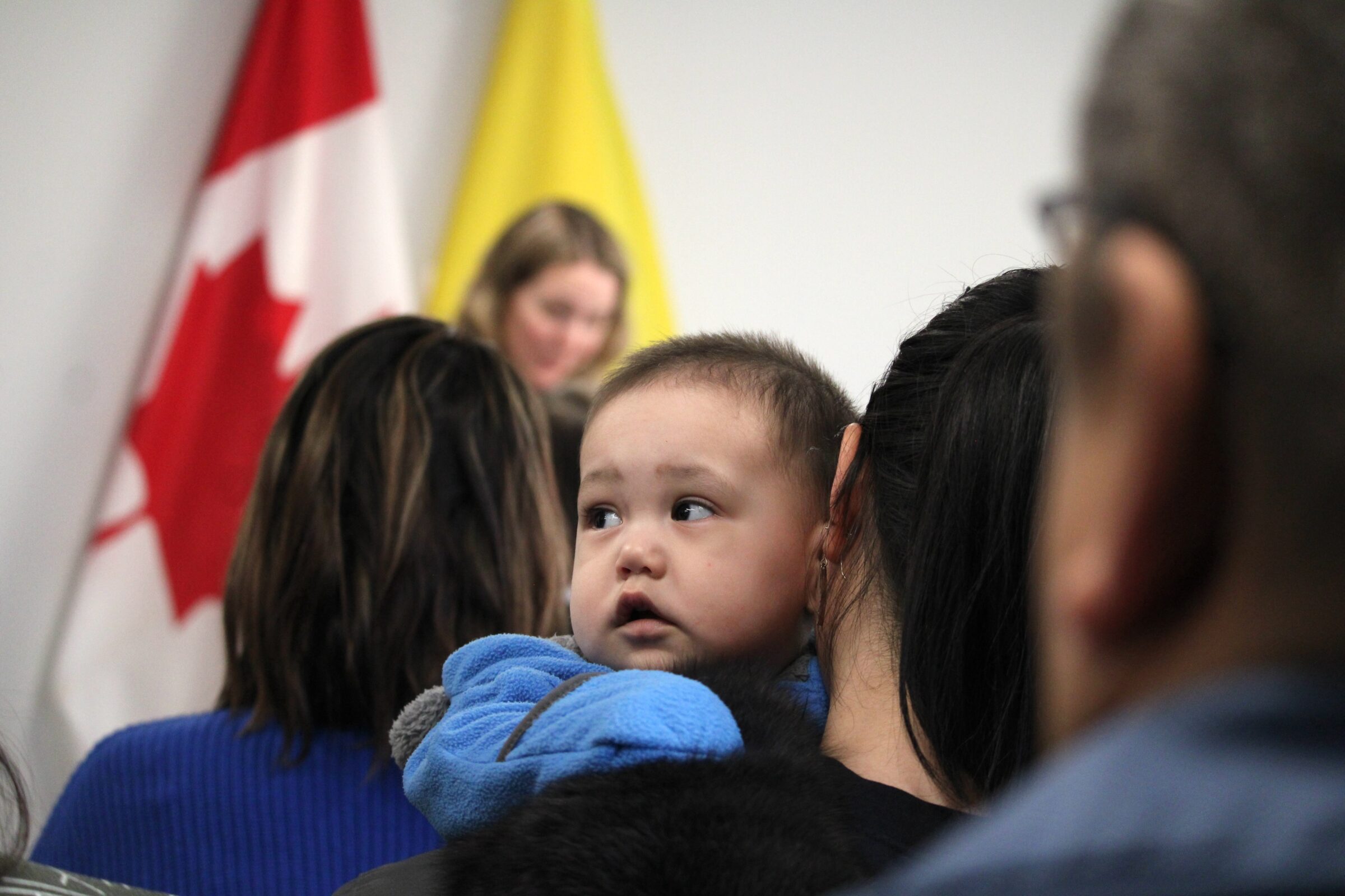 Eleven-month-old Jackson Enook-Churchill holds tight to his mother Uluappak Enook during the opening ceremony Feb. 28 of the new home for Tumikuluit Saipaaqivik Child Care Centre in Apex. It moved there from its former site downtown. Baby and mom were among approximately 40 people who came to the ceremony at Iqaluit’s only Inuktitut daycare, along with Jenna Sudds, the federal minister of families, children and social development, Premier P.J. Akeeagok and Nunavut NDP MP Lori Idlout. (Photo by Arty Sarkisian)