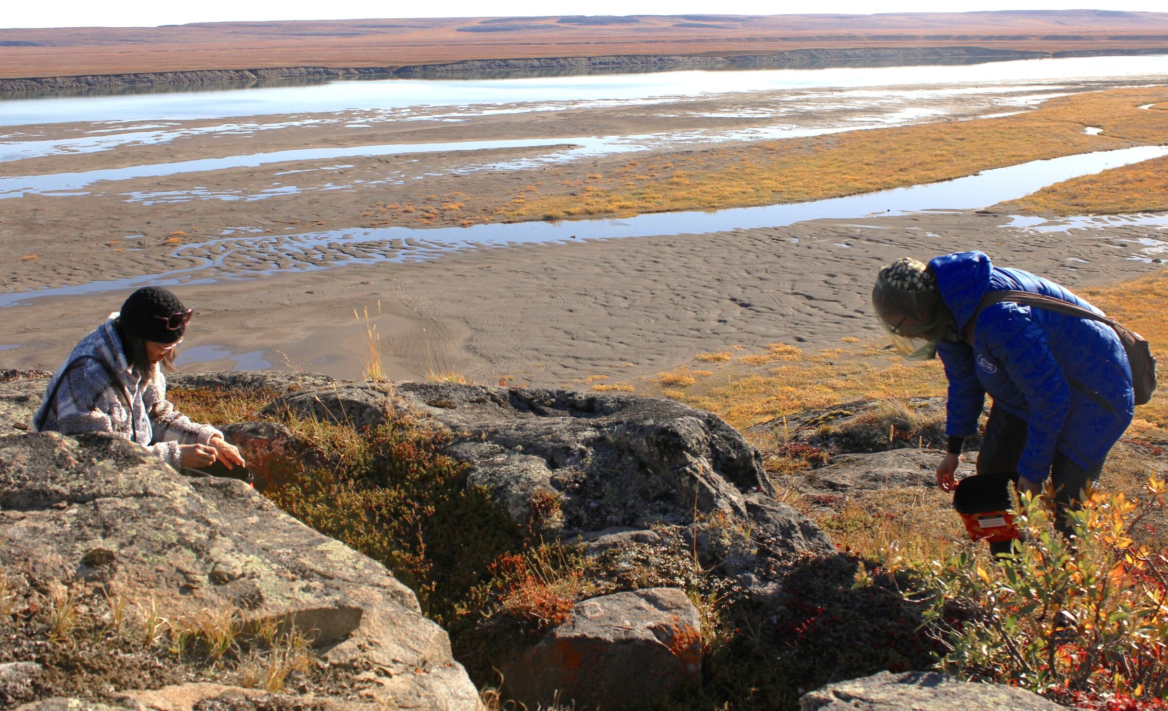 Rita Pigalak, left, and Wilma Pigalak pick cranberries and blueberries for tea and muffins on a hill just south of Kugluktuk on Sunday. The tundra is so bursting with fall colours that it looks almost like the prairies in the old westerns, Rita said. “The only thing that’s missing is a cowboy on a horse,” she joked. (Photo by Arty Sarkisian)