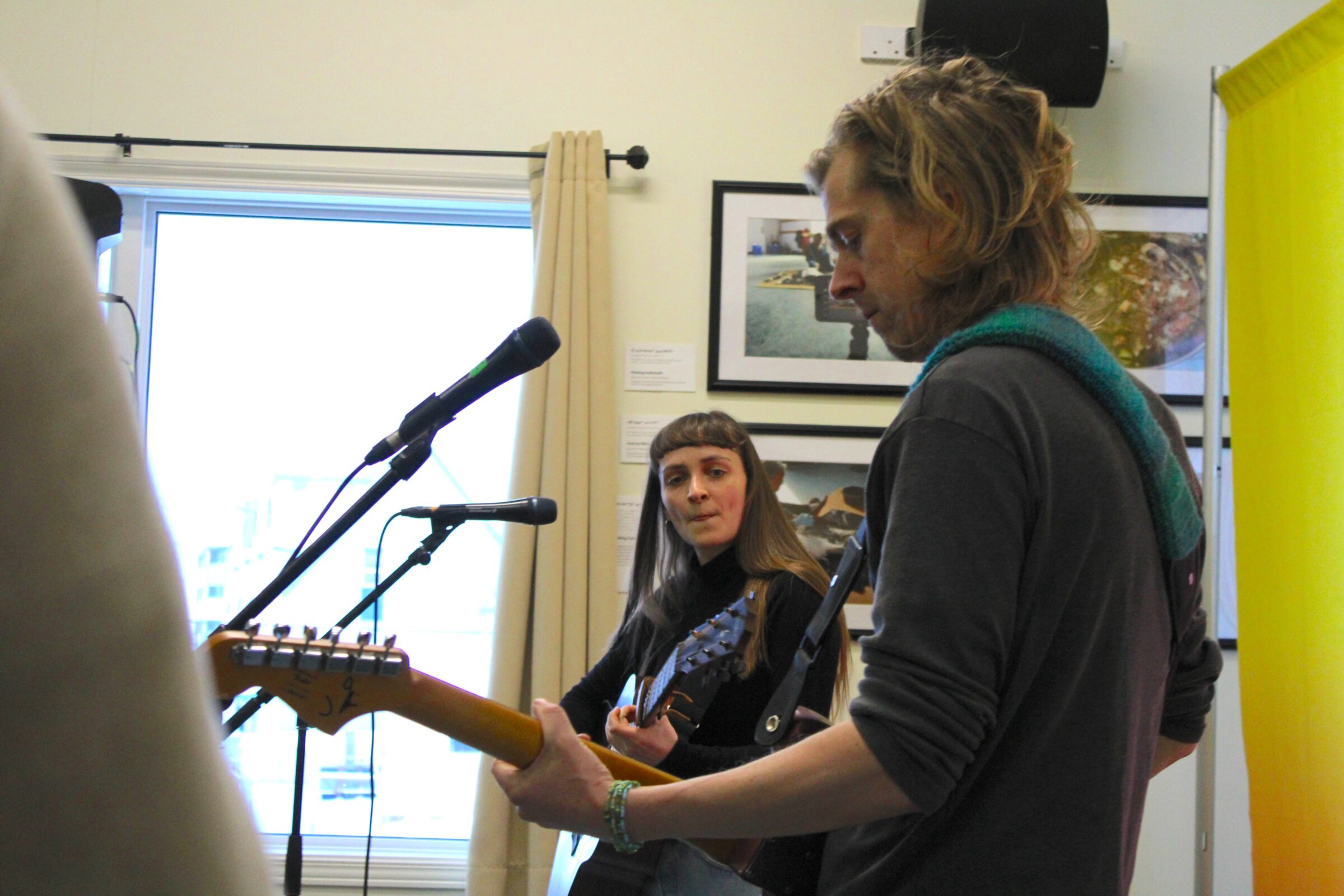 Susánna Herálvsdóttir, left, and Aske Mattias Folkmann perform at the Qajuqturvik Community Food Centre in Iqaluit on Thursday. They are two of several Arctic musicians taking part in the 2025 Pan-Arctic Vision concert in Iqaluit on Nov. 29. “It’s so cool to share our music in a soup kitchen,” Herálvsdóttir said as some of the about 60 guests ate chicken noodle soup while enjoying the music. (Photo by Arty Sarkisian)